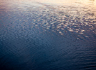 Obraz premium background. waves on the river / sea / ocean in the reflection of sunset / dawn.