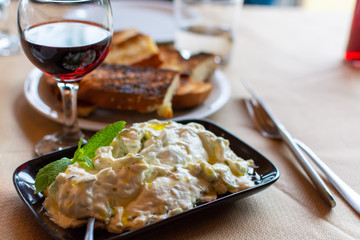 Tzatziki, dip or sauce from Southeast Europe and Middle East made of salted strained yogurt mixed with cucumbers, garlic, salt, olive oil, vinegar or lemon juice, and dill, mint, parsley and thyme.