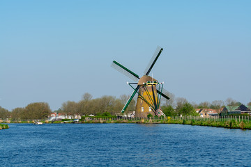 Naklejka premium Waterways of North Holland and view on traditional Dutch wind mill, spring landscape