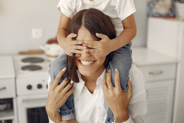Cute little son with mother. Family at home in a kitchen