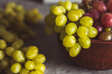 close-up of grapes on a plate on a gray background with drops of water