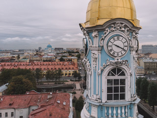 Photo of old blue belfry with clocks on each side of the tower. The bell tower is crowned by a...