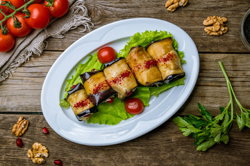Eggplant rolls stuffed with nuts on wooden table