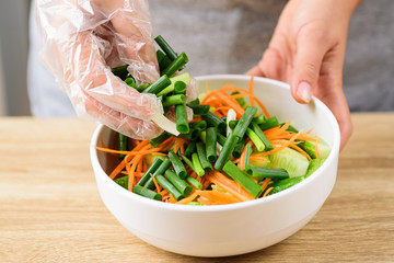 Kimchi cucumber cooking step 3, mixing sliced spring onion, carrot and cucumber together in a bowl