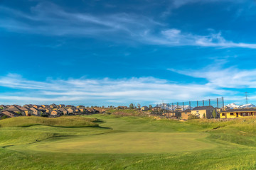 Golf course and homes with view of snow covered mountain peak in the distance