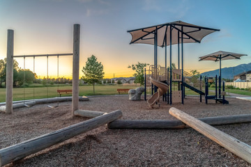 Neighborhood park with fun playground featuring slides and swings for children