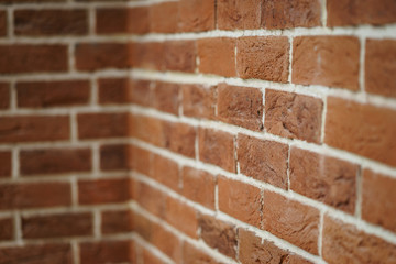 Red brick wall closeup. Abstract background. Brickwork and glue, gray seams between bricks.