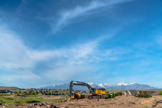 Yellow Construction Machinery With Constinuous Tracks And Metal Arm And Bucket