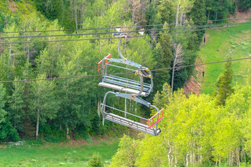 Chairlifts with aerial view of ski resort covered in greenery during off season