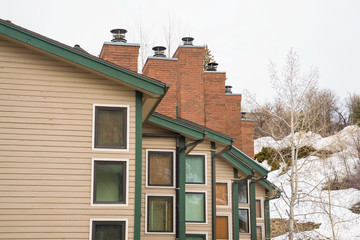 Townhomes with snow covered mountain and cloudy sky background in winter