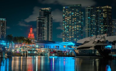 city night sky lights buildings boats pier tower colors water bay