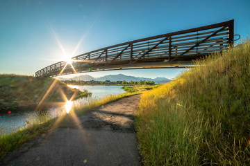 Bridge over a narrow trail along a bridge with sun and blue sky background