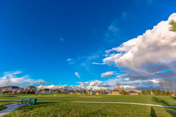 Green countryside landscape with blue sky and clouds