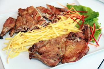 Grilled duck meat with potatoes on the dinner plate