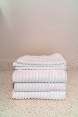 Fototapeta na wymiar Folded clean white towels on a marble top
