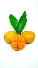 Three small fresh mangoes with leaves on closeup with white background