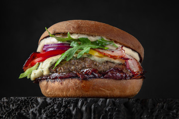 Delicious juicy burger from Brioche Bun, aged beef cutlet, bacon, Dorblu cheese, tomatoes, gherkins, iceberg, onion marmalade Hamburger for poster or menu. Free space for text.