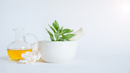 aromatherapy oil with mortar and natural green leaf on white background . aroma skin beauty spa product concept.