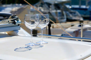 Obraz premium Pair of wineglasses against the yacht