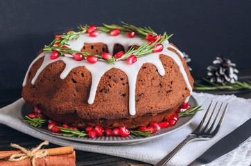 Homemade chocolate Christmas cake decorated with rosemary and pomegranate, front view