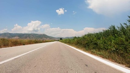 POV, Driving Plate - car driving on a straight countryside road in Greece on a sunny summer day.