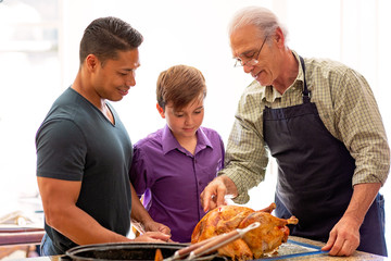 3 generations of men preparing turkey holiday dinner