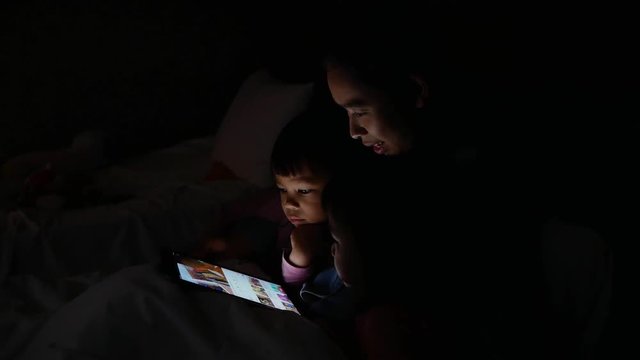 Mother and her daughter playing together in the bedroom. The child having fun to play rock-paper-scissors on the bed. family relaxation time concept.
