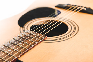Modern acoustic guitar on white background, closeup view