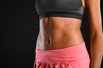 Sporty young African-American woman on dark background, closeup