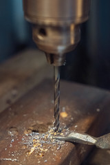 A drill press drilling a hole into metal