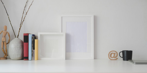 Minimal workspace with mock up frame and office supplies on white wooden table