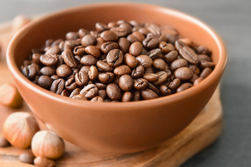 Bowl with coffee beans on table, closeup