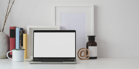 Minimal workspace with open blank screen laptop computer with office supplies and copy space