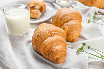 Tasty croissants with milk on table