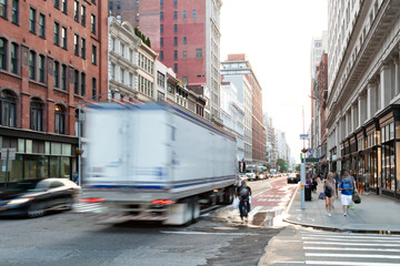 Busy view of 23rd Street with delivery truck speeding past the people walk down the sidewalk in Midtown Manhattan, New York City © deberarr