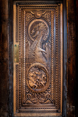 BALLINTOY HARBOUR, NORTHERN IRELAND, DECEMBER 20, 2018: Magnificent carved door with dragons and Dothraki horses, made with wood from the Dark Hedges. Location feautered in HBO Game of Thrones.