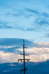 Electric pole in countryside landscape with mountains and clouds at sunset. Colombia.