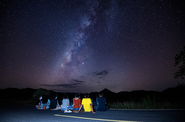 milky way galaxy with the tourist people sitting on the road looking at the sky night landscape...