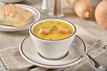 Cup of butternut squash soup with croutons