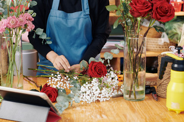 Hands of professional florist arranging bouquet at her studio