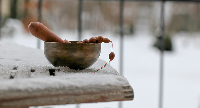 Tibetan singing bowl with its hammer on wooden table, close-up. - winter Image