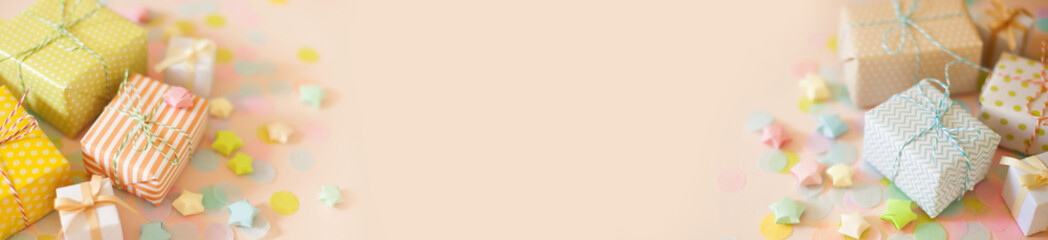 Gift boxes in pastel color. Pink long background.