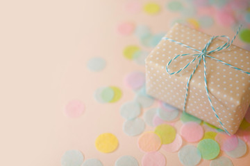 Gift boxes and pastel color confetti. Pink background.