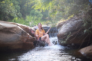 A woman playing in the  Khao Banchop waterfall, Chanthaburi, Thailand