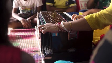 Unrecognizable Music teacher teaching students music with harmonium, slow track forward shot
