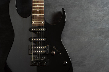 Black electric guitar on black cement floor. Top view and copy space for text. Concept of rock...