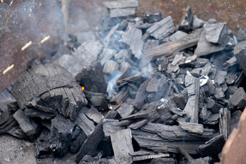 Charcoal ignition on a brazier. Light smoke and selective focus.