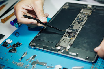 Fototapeta na wymiar Close-up image of professional repairman assembling digital tablet