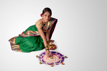 Portrait of Maharashtrian girl celebrating festival with rangoli & oil lamps  - Image