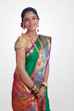 Beautiful Indian marathi bride in traditional Green navwari Saree.Bride looks beautiful in white background.